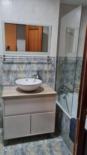 a bathroom with a sink and a mirror and a tub at Casa de Claudia Comillas- Jardín privado - A 10 metros del Capricho de Gaudí in Comillas