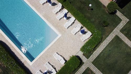 an overhead view of a swimming pool with lawn chairs at Makara Case Vacanza in Eraclea Minoa