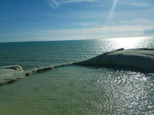 a rock sticking out of the water next to the ocean at Makara Case Vacanza in Eraclea Minoa
