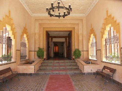 a hallway with stairs and a chandelier in a building at Hôtel Le Tinsouline in Zagora