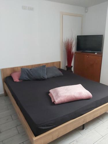 a bed with a pink pillow on top of it at Superior Motel in Haifa
