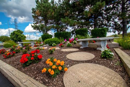 a park bench and flowers in a garden at Motel 6-Amherst, NY - Buffalo in Amherst