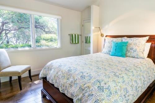 1 dormitorio con cama, ventana y silla en Lawndale Escape, en Kenwood