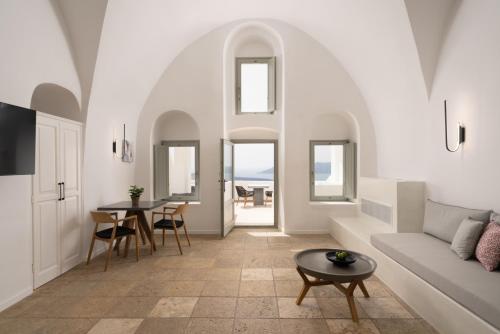 a living room with a couch and a table at Asha Luxury Suites in Fira