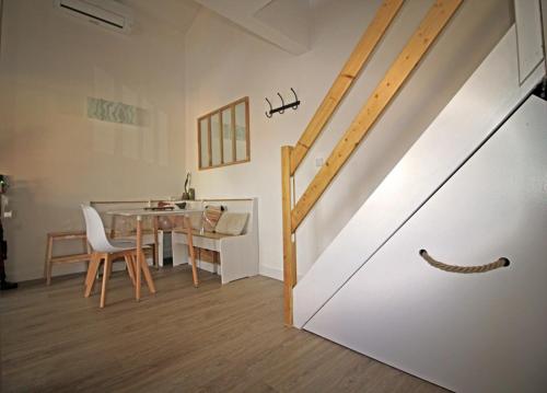 ein Esszimmer mit einem Tisch und einer Holztreppe in der Unterkunft Villa Mer Nature in Frontignan