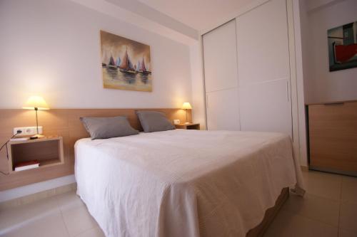 ein Schlafzimmer mit einem großen weißen Bett in einem Zimmer in der Unterkunft Apartamento en Vera a 300 m de la playa, con patio y salida directa a calle in Vera