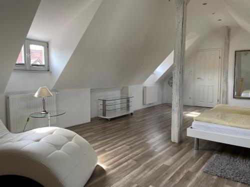 a white room with a bed and a staircase at Ambiente in Bamberg