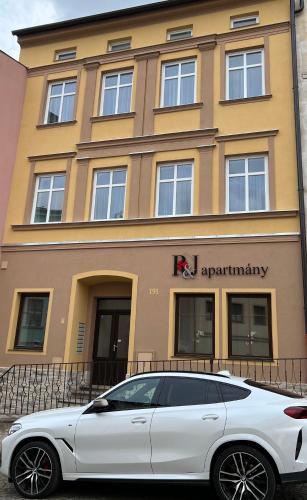 a white car parked in front of a building at R&J apartmány in Broumov
