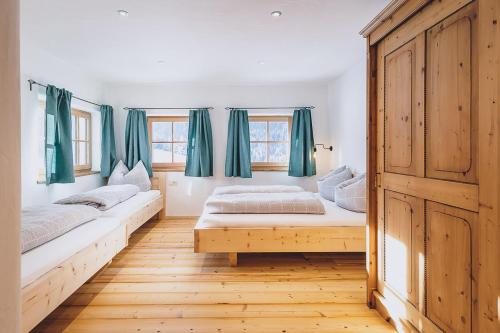 sypialnia z 2 łóżkami i zielonymi zasłonami w obiekcie Appartement Adamhof Spielberg Leogang w mieście Leogang