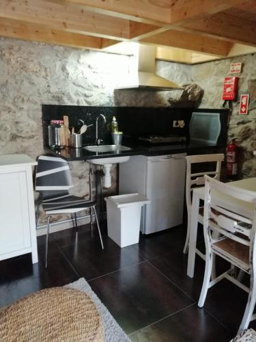 a kitchen with a sink and a table and chairs at Casa da Portela in Caminha