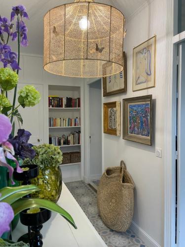 Habitación con lámpara de araña y mesa con flores. en Un palmier à sa fenêtre en Grasse