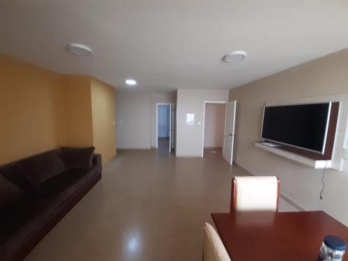 uma sala de estar com um sofá e uma televisão de ecrã plano em Departamento en el centro de la ciudad em Encarnación