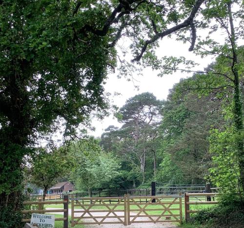 a wooden fence in front of a field with trees at Self Catering Apartment, Jurassic Coast/Dorset in Wareham