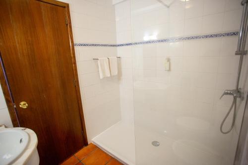 a bathroom with a shower and a toilet and a sink at Downtown PDL in Ponta Delgada