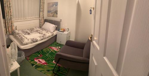um pequeno quarto com uma cama e uma cadeira em ABIMDOT Exquisite apartments em Manchester