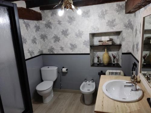 a bathroom with a white toilet and a sink at Villa castellanos in Isla