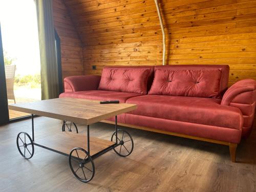 a red couch sitting in a room with a table at Nefes URLA Bungalov 3 in Urla
