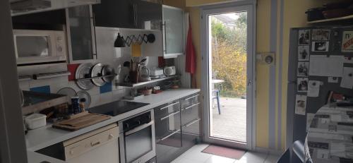 a kitchen with a sink and a door to a patio at Maison et jardin Nantes Chantenay in Nantes