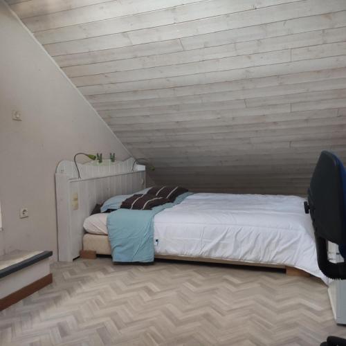 un lit dans une chambre avec un mur en bois dans l'établissement Maison et jardin Nantes Chantenay, à Nantes