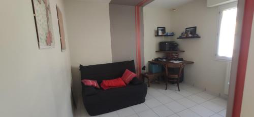 a living room with a black chair with two red pillows at Maison et jardin Nantes Chantenay in Nantes