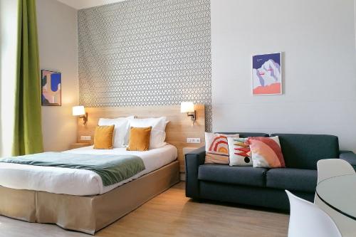 a bedroom with a bed and a couch at Ajoupa Aparthotel AMMI Massena in Nice