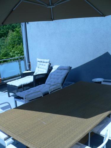 a table and chairs and an umbrella in a room at liège 4420 rue jean Jaurès 45 grande maison joyeuse avec terrasse 30m2 pour 8 personnes maximum in Saint-Nicolas