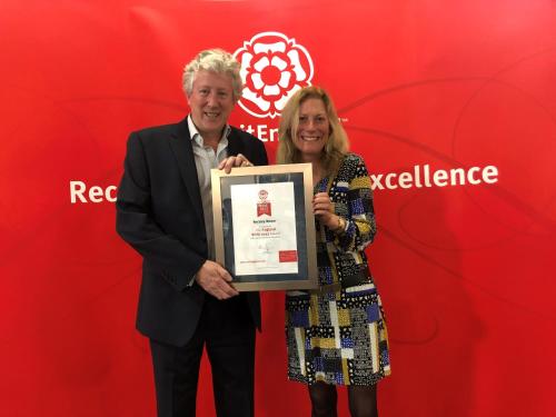 a man and a woman holding up a framed award at Rectory Manor in Lavenham