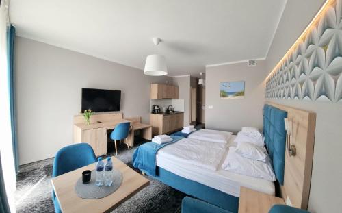 um quarto de hotel com uma cama, uma mesa e cadeiras em Cesarskie ogrody 102A By Edyta em Świnoujście