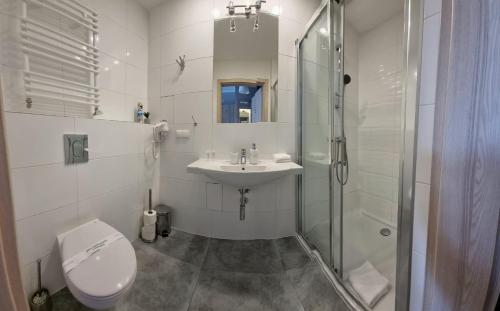 uma casa de banho com um WC, um lavatório e um chuveiro em Cesarskie ogrody 102A By Edyta em Świnoujście