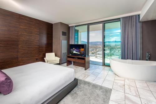 a bedroom with a bed and a tub and a television at Palms Place One Bedroom Suite 1220 sqft in Las Vegas