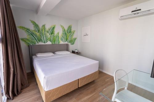 a bedroom with a bed with a plant on the wall at Ecco Hotel Fortaleza in Fortaleza