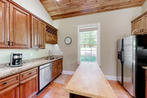 a kitchen with wooden cabinets and a stainless steel refrigerator at The Dawg Pound in Maynardville