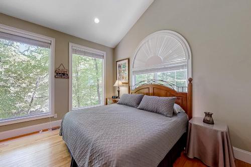 a bedroom with a bed and two windows at The Dawg Pound in Maynardville
