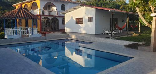 a house with a swimming pool in front of a house at Finca Las Mercedes en encantador entorno natural in El Triunfo