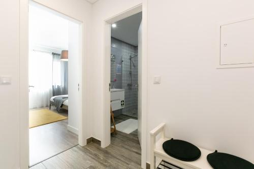 a white bathroom with a mirror and a sink at SURFERS PARADISE in Peniche