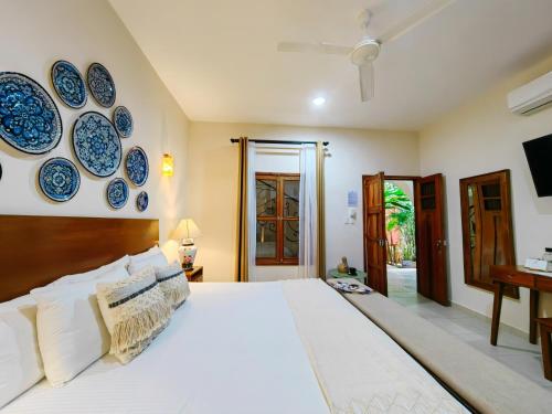 a bedroom with a bed with blue plates on the wall at Le Muuch Hotel Boutique in Valladolid