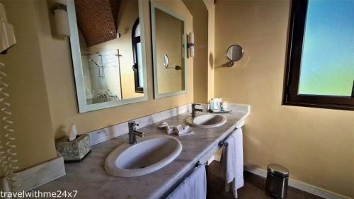 a bathroom with two sinks and a large mirror at Private guest house in five stars resort in Ras al Khaimah