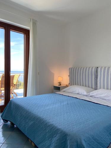- une chambre avec un lit bleu et une vue sur l'océan dans l'établissement SunSea Apartments Pisciotta, à Pisciotta