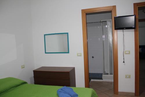 ein Schlafzimmer mit einem Bett und einem TV an der Wand in der Unterkunft Casa Vacanze Vista al Mar in Marina di Camerota