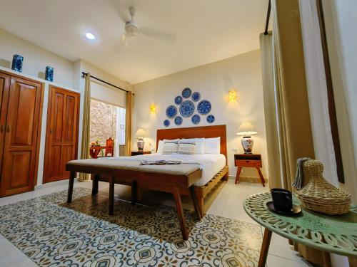 a bedroom with a bed and blue plates on the wall at Le Muuch Hotel Boutique in Valladolid