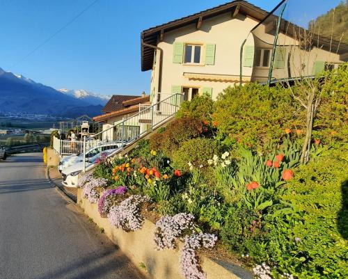 a house with flowers on the side of a road at Grand appartement 6 personnes, surf, ski et randonnées in Nendaz