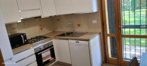 a kitchen with white cabinets and a sink and a stove at L'incanto home in Bologna