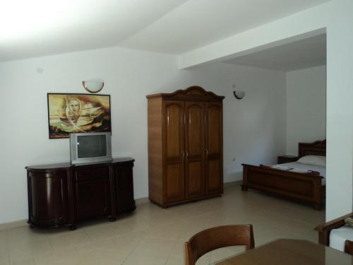 a living room with a bed and a tv on a cabinet at Vila Horizont in Sveti Stefan
