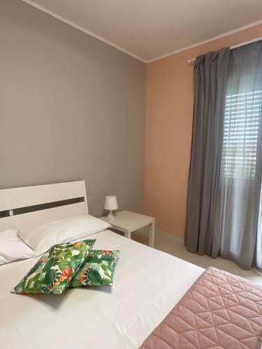 Schlafzimmer mit einem Bett mit einem Kissen und einem Fenster in der Unterkunft Sicily Emotion in Giardini-Naxos