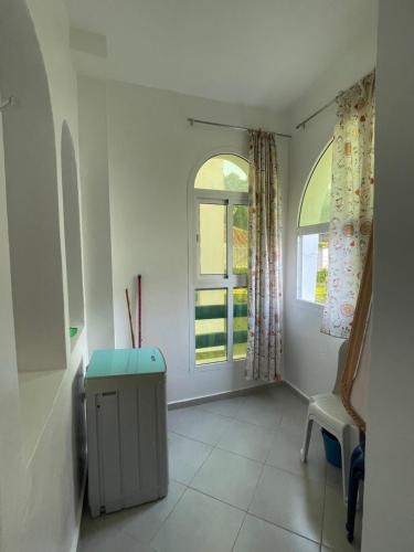a white room with a chair and a window at Résidence Lilia Al Jabal M’diQ in M'diq