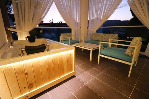 a bathroom with a tub and chairs and a window at Garcia Resort & Spa - Ultra All Inclusive in Oludeniz