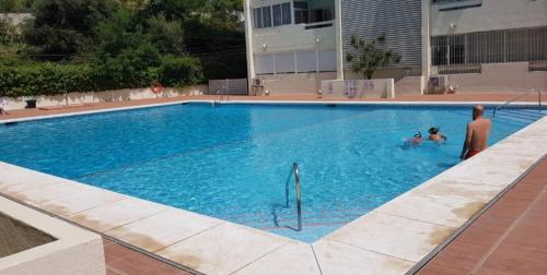 - 2 personnes dans une grande piscine dans l'établissement Piso reformado a estrenar cerca playa y centro, à Marbella