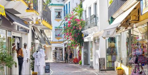 a group of people walking down a street with buildings at Piso reformado a estrenar cerca playa y centro in Marbella