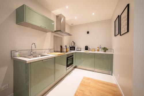 a kitchen with green cabinets and a sink at Le Casa-blanca Magnifique Appartement chic&cosy in Collobrières