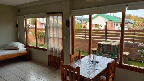a dining room with a table and some windows at ROCA AZUL in El Bolsón